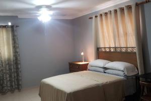 een slaapkamer met een bed en een lamp op een tafel bij Casa Agate - 2 BR Condo w/Parking Gazcue in Santo Domingo