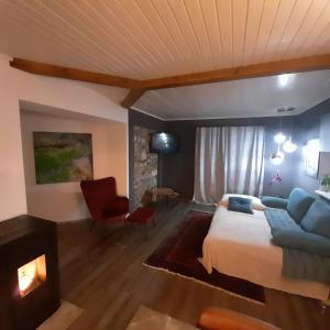 a bedroom with a bed and a couch and a fireplace at Lintschis Ferienwohnung in Vorderberg