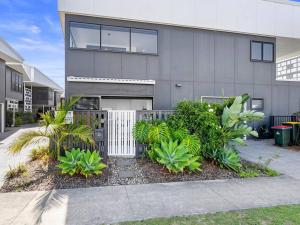 a house with a fence and plants in front of it at 1 Bedroom Modern Townhouse in Casuarina in Casuarina