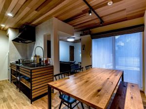una cucina e una sala da pranzo con tavolo in legno di Rakuten STAY HOUSE x WILL STYLE Yufuin Kawakami 101 a Yufu