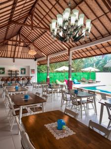 ein Restaurant mit Tischen und Stühlen und einem Pool in der Unterkunft Kesari Glory Nusa Penida by GenuineHost in Nusa Penida + 51 Fotos