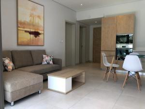 een woonkamer met een bank en een tafel bij Montecrista Appart moderne et cosy, 1 chambre à 2 min plage Pereybere in Pereybere