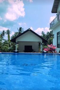 a view of a swimming pool in front of a house at Captain's Cabin Resort - Naval Heritage (Swimming Pool) in Kota Bharu