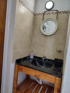 y baño con lavabo y espejo. en Complejo Monaco Calamuchita en Santa Rosa de Calamuchita