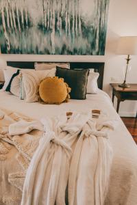 un letto con coperte bianche e cuscini sopra di Araluen Boutique Accommodation a Yarra Glen