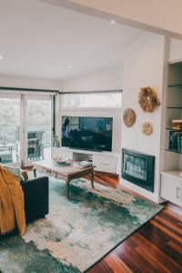 a living room with a tv and a fireplace at Araluen Boutique Accommodation in Yarra Glen