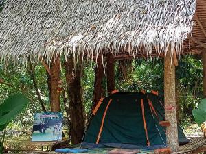 a hut with a thatched roof with a table and a sign at Wassana Camp & Khai Jungle Experience Centour in Ban Kraison