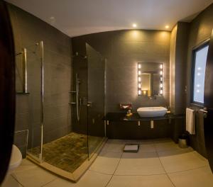 La salle de bains est pourvue d'une douche, d'une baignoire et d'un lavabo. dans l'établissement Rysara Hotel, à Dakar