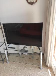 una TV a schermo piatto seduta su un supporto in camera di Comfortable apartment on the 10t floor with seesight and balcony a El Campello