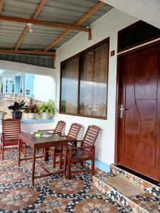 um pátio com uma mesa e cadeiras e uma porta de madeira em TOHO NIAS em Telukdalem