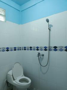 ein Badezimmer mit einem WC und einer Dusche mit blauem Licht in der Unterkunft TOHO NIAS in Telukdalem