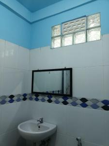 a bathroom with a sink and a mirror at TOHO NIAS in Telukdalem +25 photos