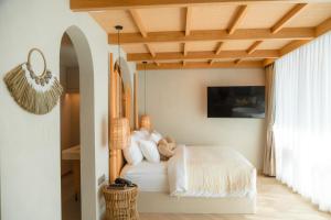 um quarto com uma cama branca e um tecto de madeira em Maldives Beach Resort em Praia de Chao Lao
