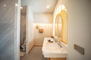 a bathroom with a sink and a mirror at Maldives Beach Resort in Chao Lao Beach