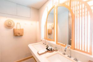 a bathroom with a sink and a mirror at Maldives Beach Resort in Chao Lao Beach