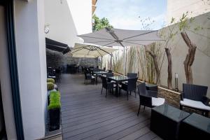 a wooden deck with tables and chairs and umbrellas at Rysara Hotel in Dakar