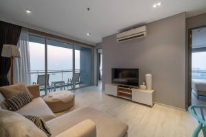 a living room with a couch and a television at Veranda Pattaya/3BR Seaview/32FL in Jomtien Beach