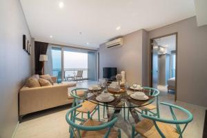 a living room with a table and chairs and a couch at Veranda Pattaya/3BR Seaview/32FL in Jomtien Beach