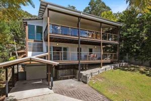 波因特卢考特Treetops on Tramican - Ocean View - sleeps 10的带阳台和庭院的大房子