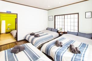 a bedroom with three beds with towels on them at Vacation rental Miyabi/downtown/Tokyo airport in Tokyo