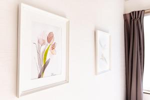 two framed prints of flowers on a wall at Vacation rental Miyabi/downtown/Tokyo airport in Tokyo