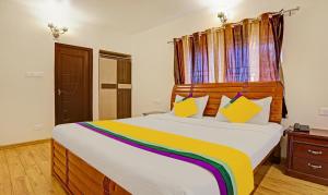 a bedroom with a large bed with a wooden headboard at Itsy By Treebo - Twin Falls in Ooty