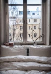 um quarto com 2 camas e uma grande janela em Elegant city home two blocks from Senate Square. em Helsinque