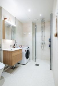 uma casa de banho com um lavatório e uma máquina de lavar roupa em Elegant city home two blocks from Senate Square. em Helsinque
