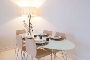 a white dining room with a white table and chairs at Elegant city home two blocks from Senate Square. in Helsinki