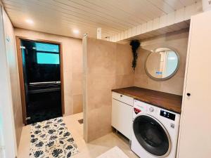 a small laundry room with a washer and dryer at Welcoming shared room with free parking and sauna in Vantaa