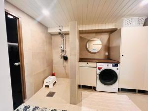 a small laundry room with a washer and dryer at Welcoming shared room with free parking and sauna in Vantaa