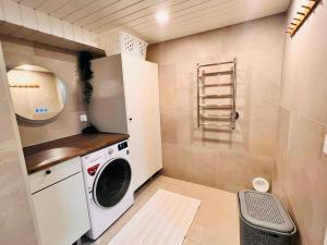 uma pequena lavandaria com máquina de lavar e secar roupa em Welcoming shared room with free parking and sauna em Vantaa