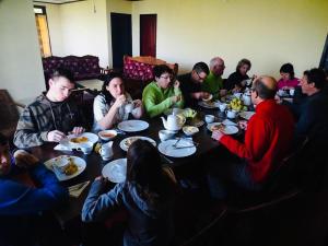 a group of people sitting around a table eating food at Misty Mountain Lodge Ohiya in Ohiya +17 photos
