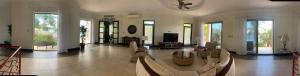 una gran sala de estar con sofás y ventilador de techo. en Room in Apartment - Agradable Habitacion En Playa Flamingo, en Playa Flamingo