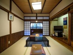 a living room with a table and a tv at Yunohira Kamiyanagiya in Yufuin