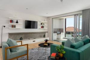 sala de estar con sofá y TV en Elements Luxury Suites by Totalstay, en Ciudad del Cabo