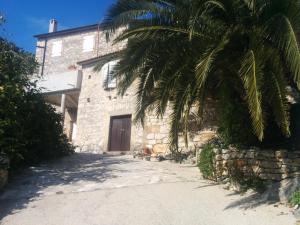 a building with a palm tree in front of it at Holiday Home Rubinić in Zavala
