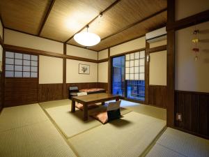 um quarto com uma mesa e uma grande janela em Yunohira Kamiyanagiya em Yufu