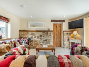 a living room with couches and a stone wall at The New Stables in Melbourne