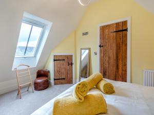a bedroom with a bed with yellow walls and a window at The New Stables in Melbourne
