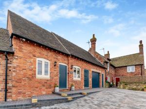 a brick house with blue doors and a driveway at The New Stables in Melbourne