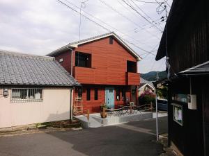 uma casa vermelha com uma garagem branca em frente em MAHALO - Vacation STAY 05513v em Saikai