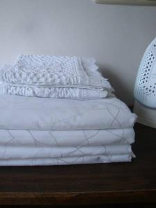 a white bed with white sheets on a wooden floor at Bed and breakfast De Zwanebloem in Elburg