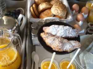 a table with a plate of bread and two glasses of orange juice at Bed and breakfast De Zwanebloem in Elburg