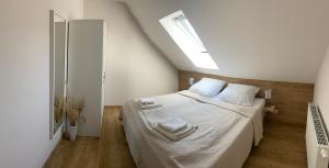 a bedroom with a bed with white sheets and a window at Gästesuite „Torfstich“ in Markische Heide