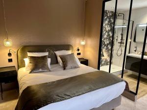 Un dormitorio con una cama grande y un espejo. en Domaine de Suzel Hôtel & Spa, en Vignieu