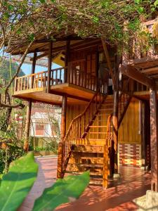 a wooden house with a staircase in the middle at Duong Cong Chich Homestay in Lạng Sơn