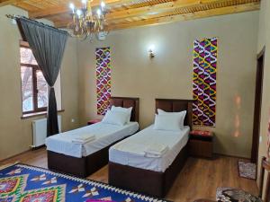 サマルカンドにあるDarvozai Samarkand guest houseのベッドルーム1室(ベッド2台、シャンデリア付)