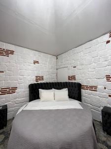Bett in einem Zimmer mit einer weißen Ziegelwand in der Unterkunft SÜİT TAŞ EV in Sakarya