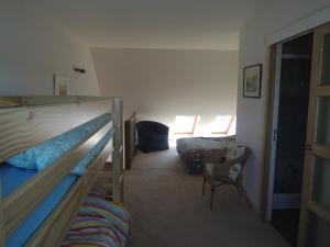 - une chambre avec 2 lits superposés et une chaise dans l'établissement Joli appartement avec wifi sur le port de Dahouet, à Pléneuf-Val-André